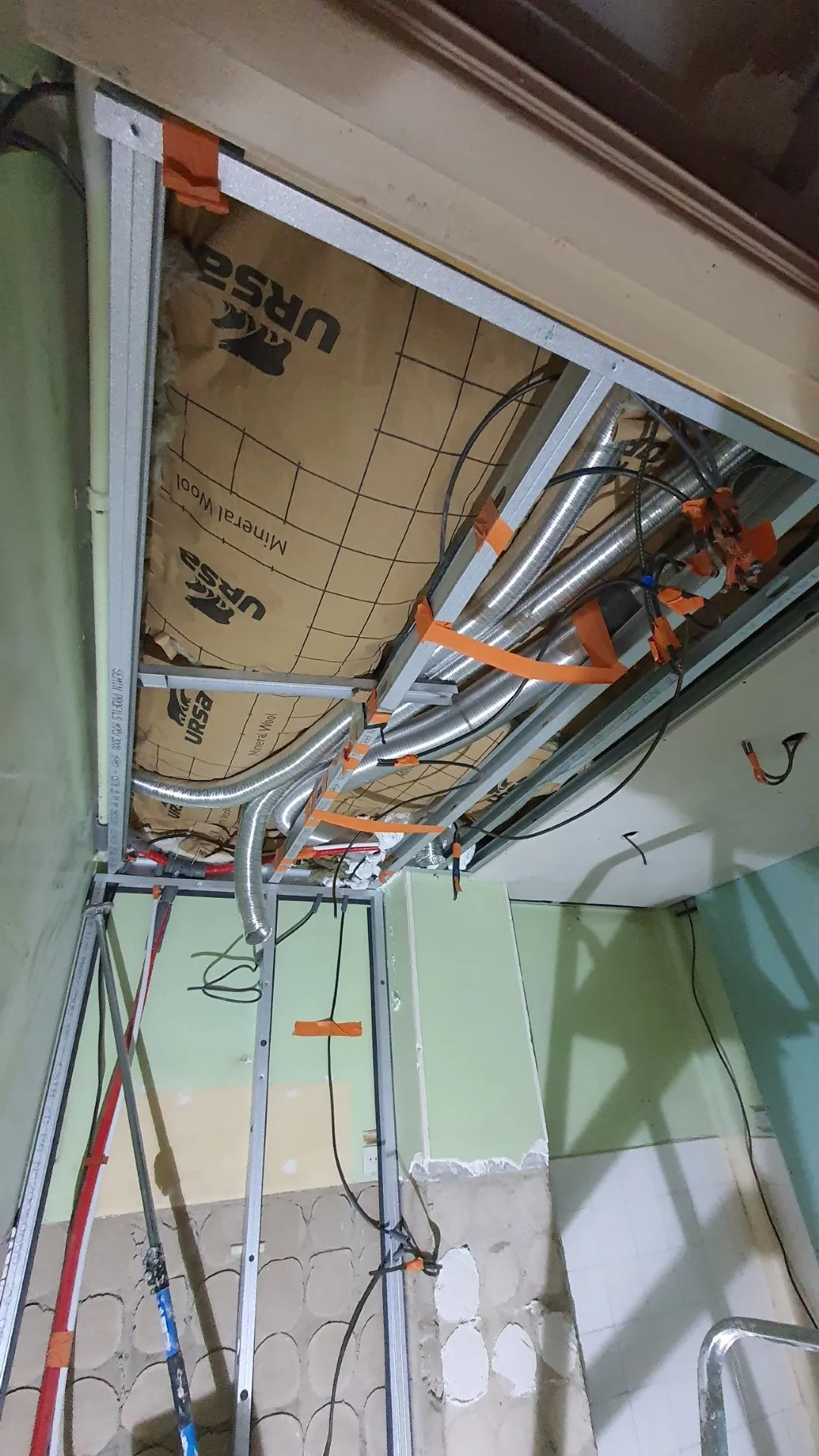 Réseau de gaines de ventilation en cours de pose au plafond du F4