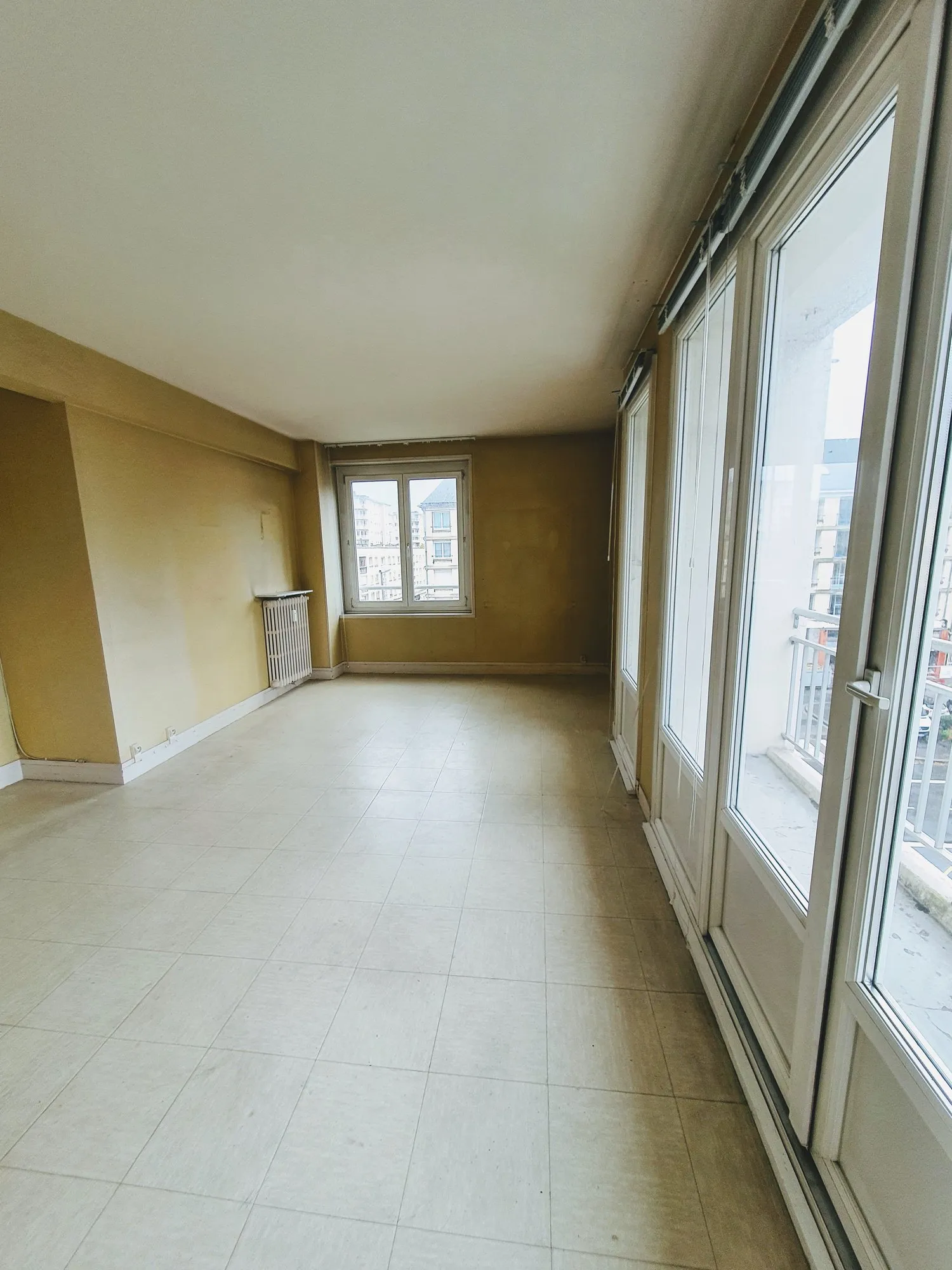 Séjour du 2 pièces avant travaux, murs moutarde