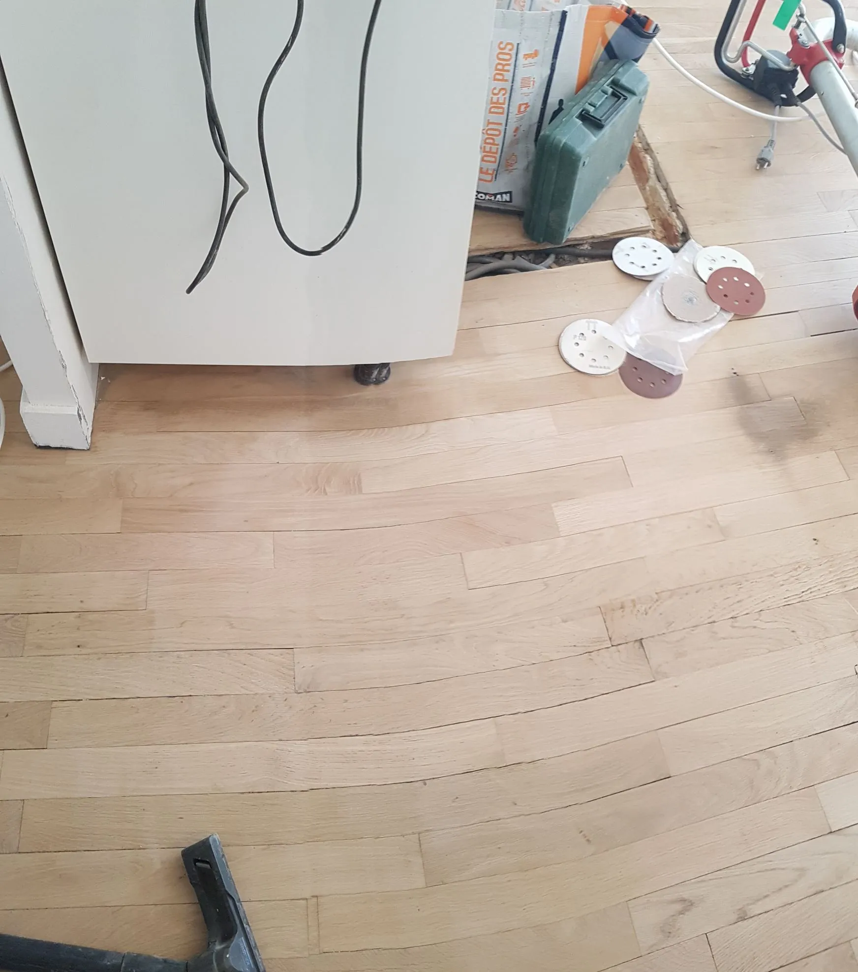 Disques de ponçage usés empilés au sol après une journée de travail