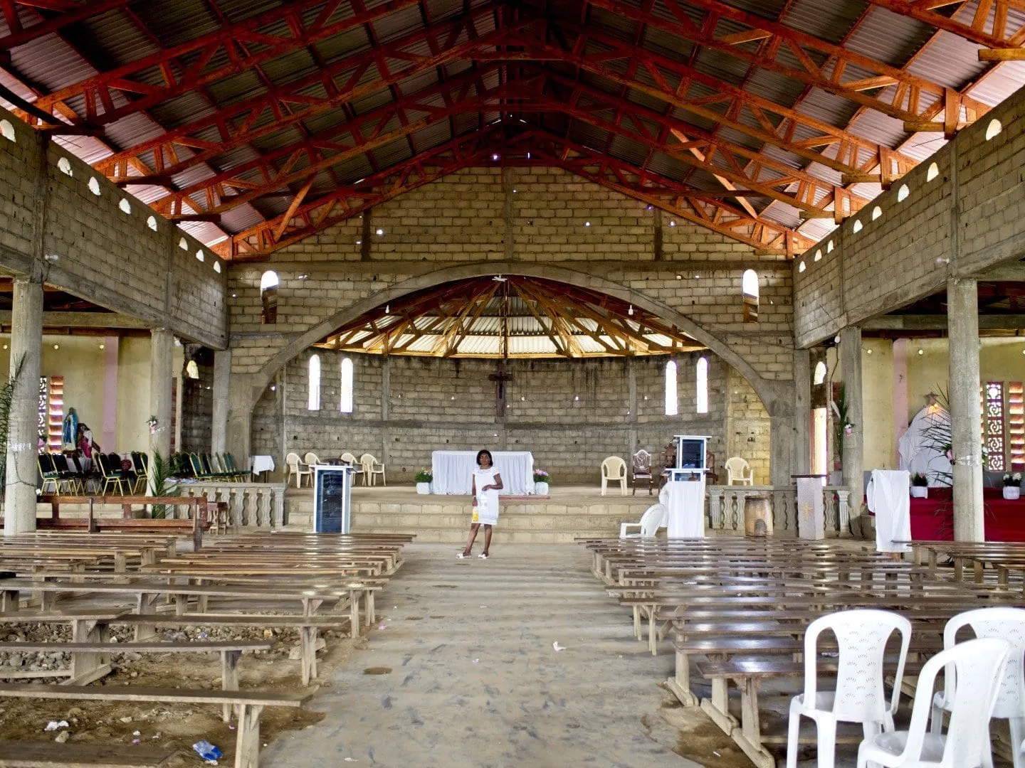 L'intérieur d'une église en enfilade, charpente apparente, autel au fond