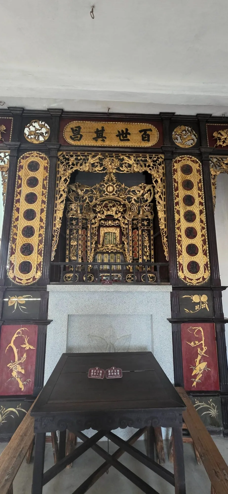 Un autel doré et sculpté à l'intérieur d'une tour diaolou