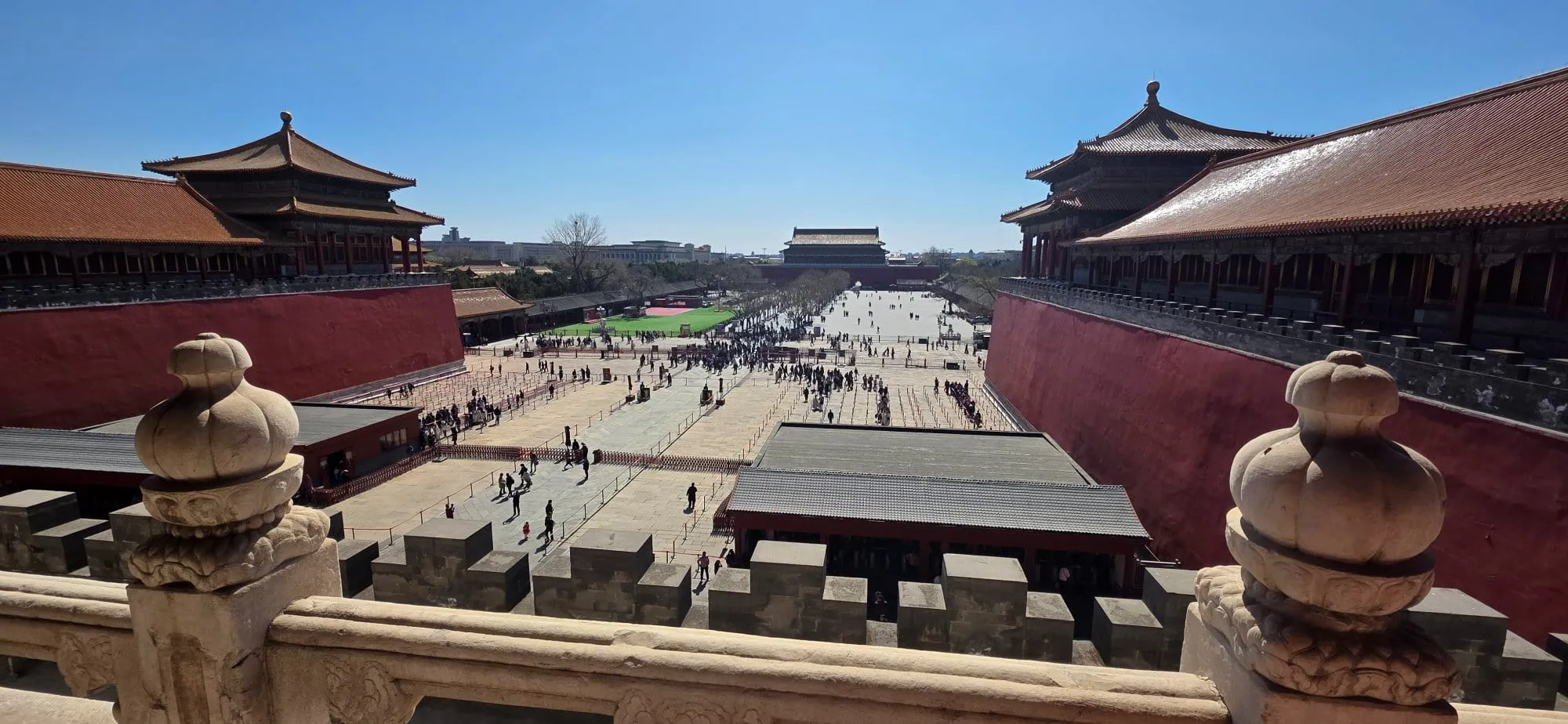 Une cour immense de la Cité interdite bordée de pavillons à toits d'or