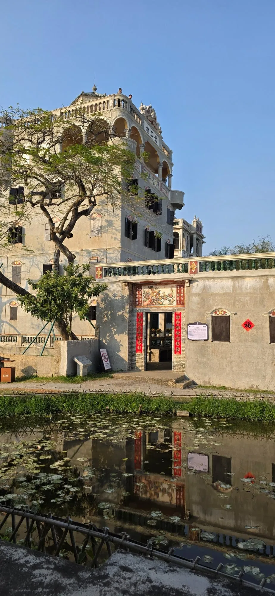 Une tour diaolou de Kaiping se reflétant dans l'eau d'une rizière au calme