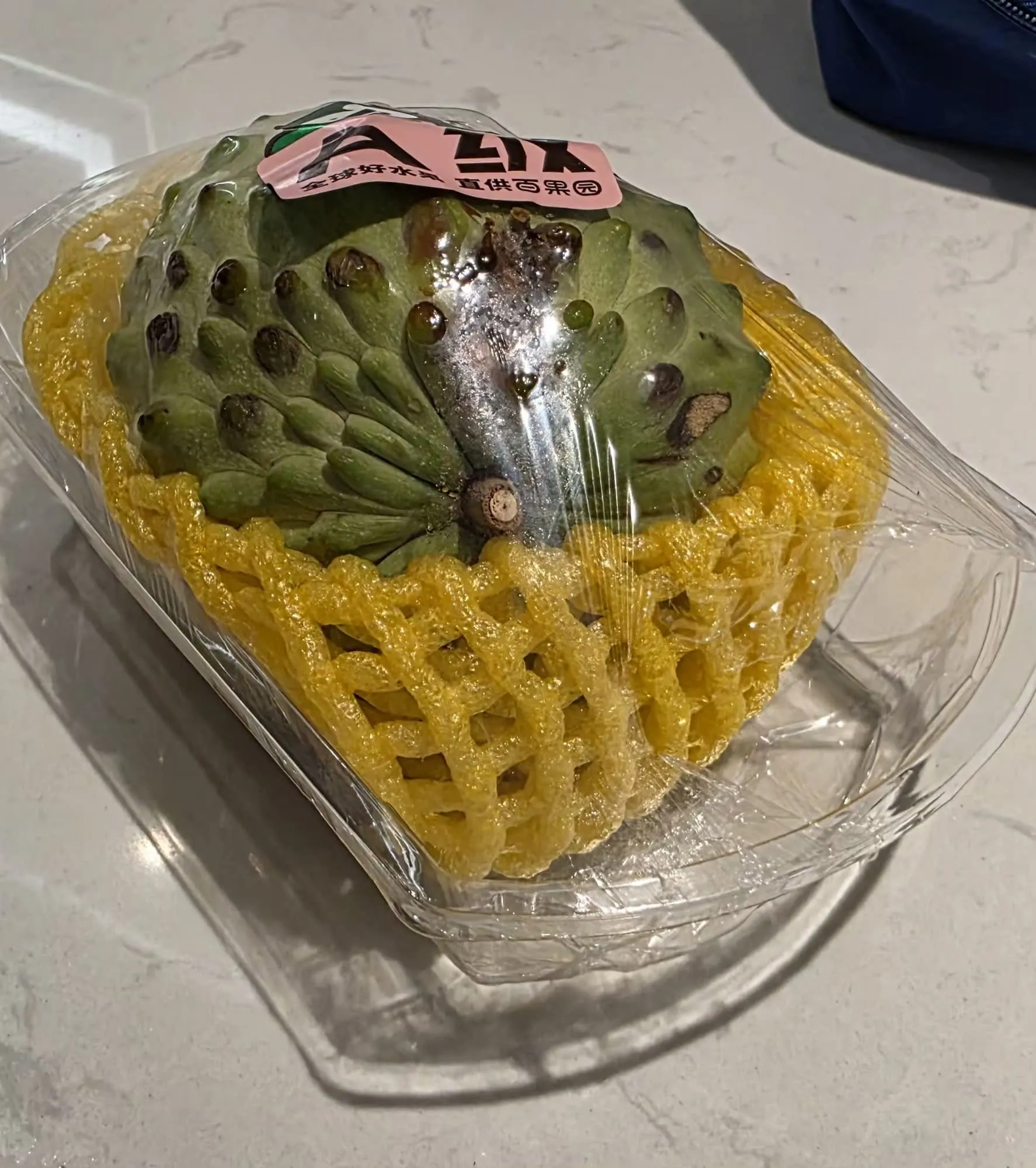 Un fruit emballé dans trois épaisseurs de film plastique et de mousse