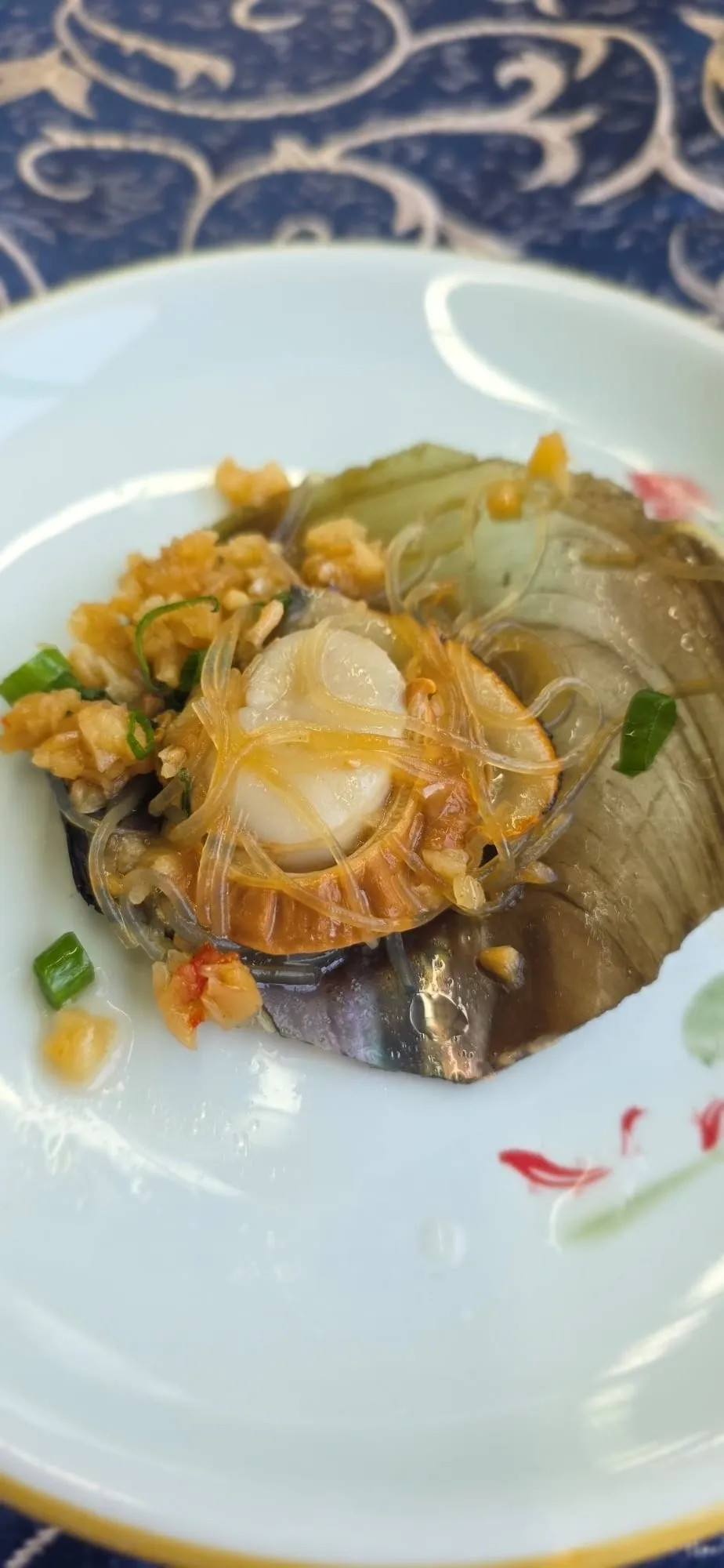 Une omelette garnie de fruits de mer dans une assiette bleue et blanche