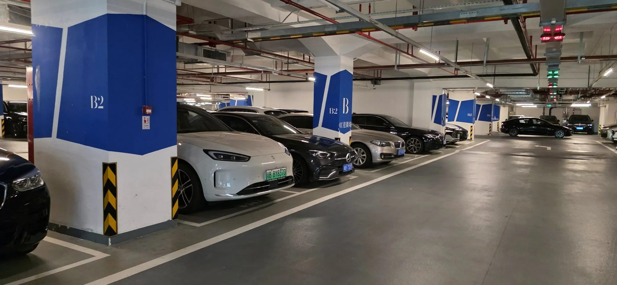 Un parking souterrain aligné de voitures électriques branchées à des bornes de recharge