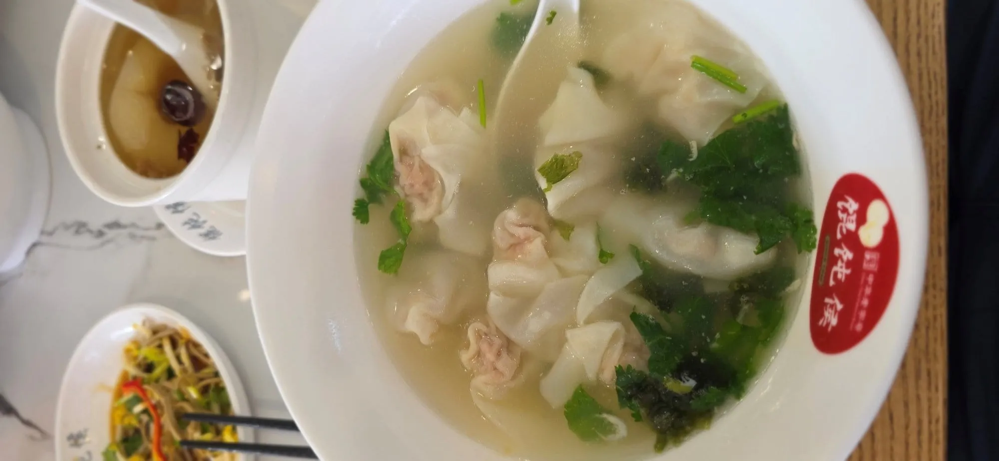 Un bol de soupe de raviolis chinois posé sur une table
