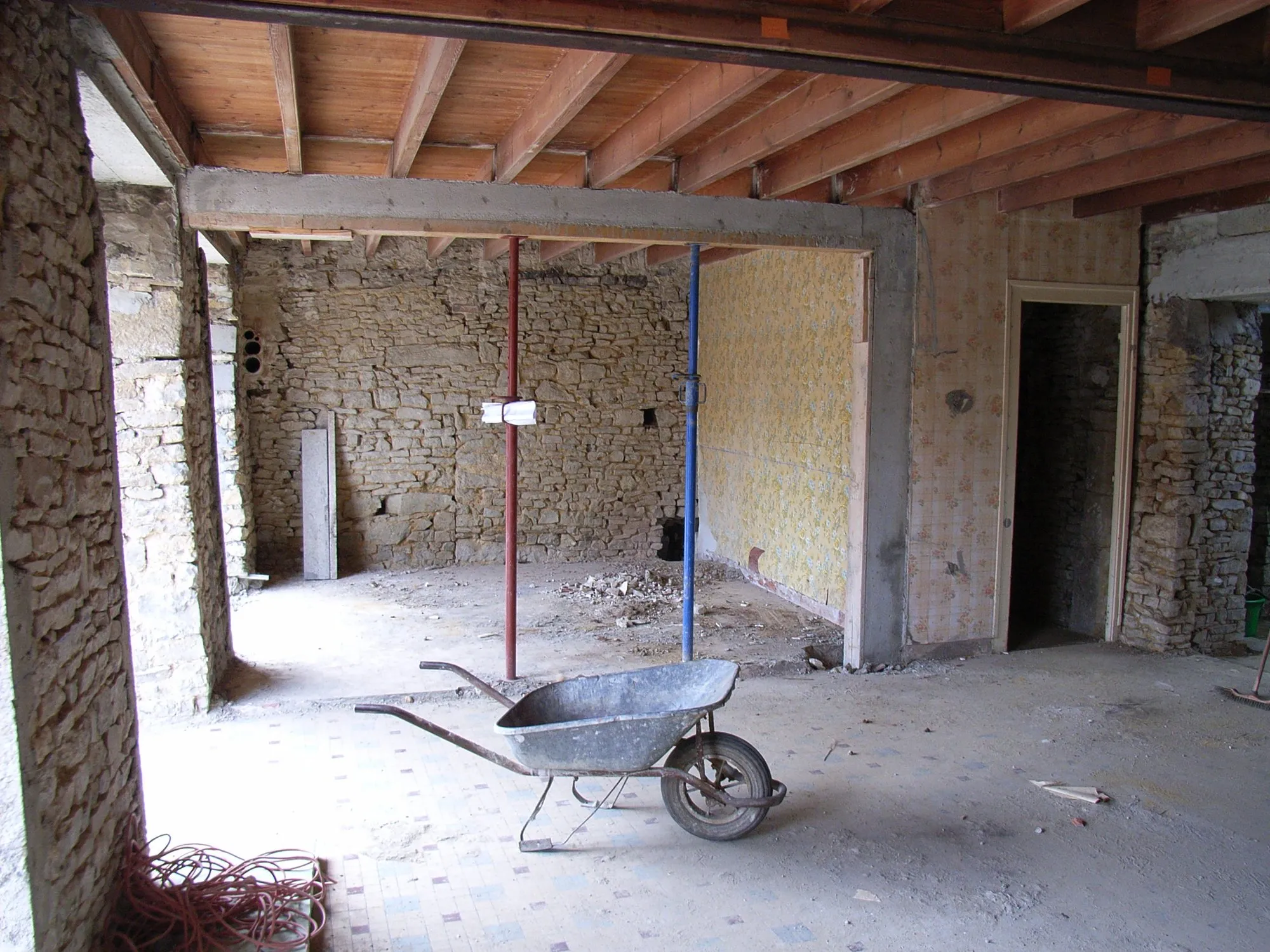 L’ancien sol carrelé, les étais et une brouette pendant les travaux