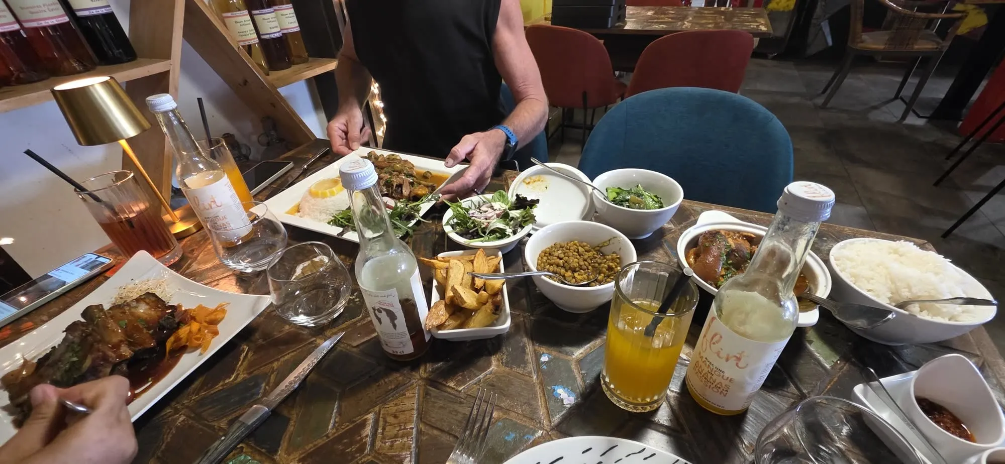 Une table de restaurant couverte de marmites, bols de riz et caris