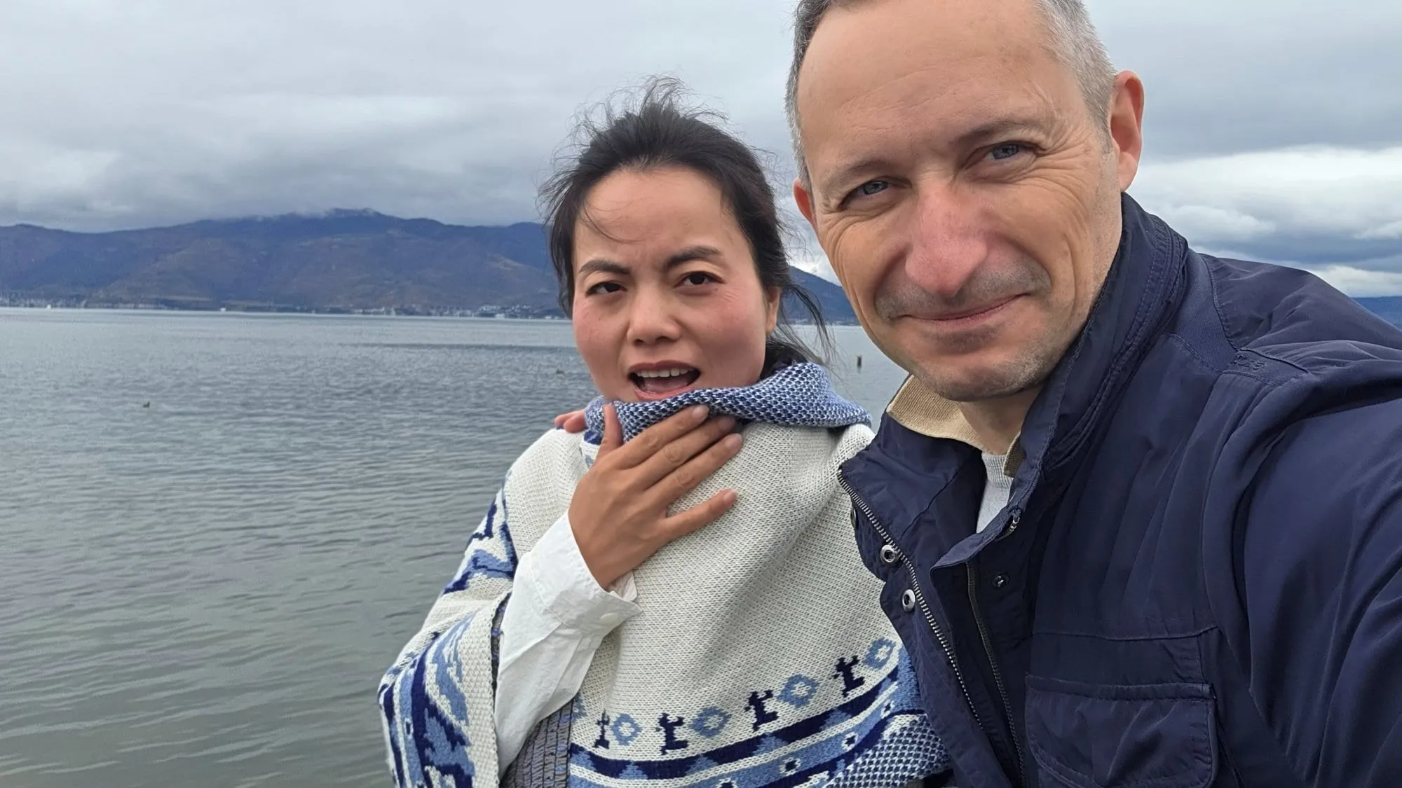 La rive du lac Erhai, eaux calmes et montagnes en arrière-plan