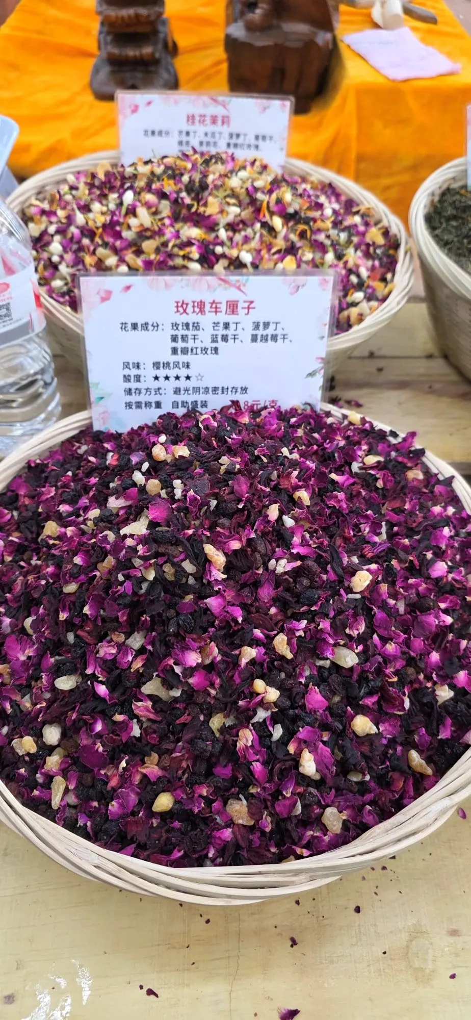 Une large bassine remplie de boutons de rose séchés, avec une étiquette de prix