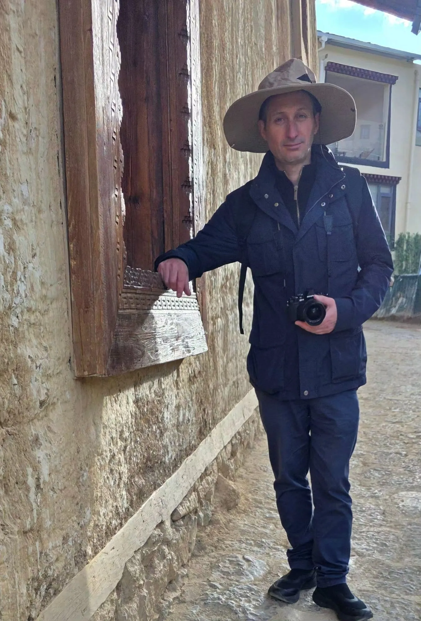 Une maison tibétaine à Shangri-La, murs épais inclinés et fenêtres cerclées de peinture