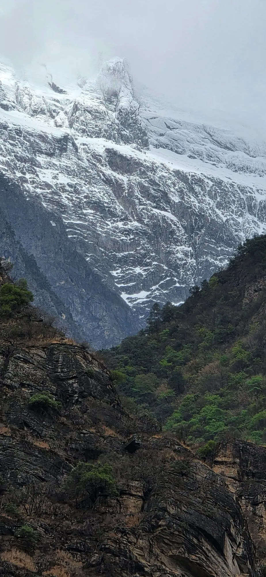 Un sommet enneigé émergeant au-dessus de collines, vu depuis la route du nord